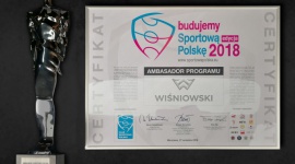 WIŚNIOWSKI ze statuetką „Budowniczy Polskiego Sportu” BIZNES, Firma - Firma WIŚNIOWSKI, czołowy producent bram, okien, drzwi i ogrodzeń, po raz kolejny została doceniona i wyróżniona. Tym razem została okrzyknięta „Budowniczym Polskiego Sportu”. Tym samym został zauważony jej wkład w budownictwo sportowe i rekreacyjne.